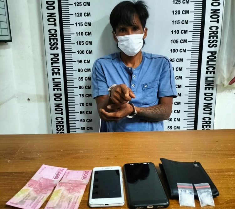 Foto pelaku menunjuk barang bukti dengan tangan diborgol.