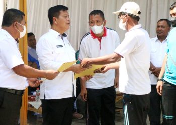 Bupati Simalungun, Radiapoh Hasiholan Sinaga, saat menyerahkan SK pengangkatan Pegawai Pemerintah dengan Perjanjian Kerja (PPPK) kepada salah seorang tenaga guru paling tua.