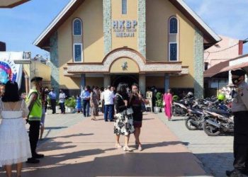 Polisi terlihat berjaga di depan pintu masuk Gereja HKBP Pabrik Tenun, Kecamatan Medan Petisa, Kota Medan, Minggu (22/5/2022)/Anugerah Nasution. TRIBUN MEDAN/ANUGRAH NASUTION