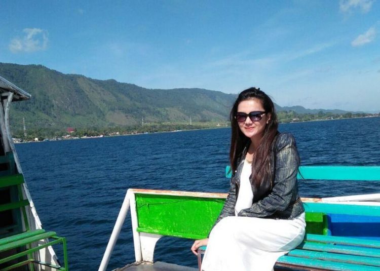 Wisatawan berpose dengan latar Danau Toba, Samosir, Sumatera Utara (Foto: Instagram/@adheaaa29)