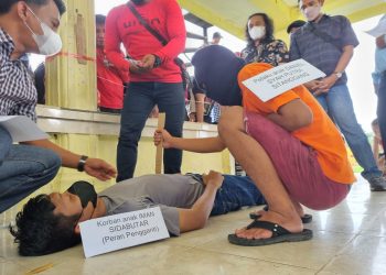 Foto pelaku memperagakan cara menghabisi nyawa korban.