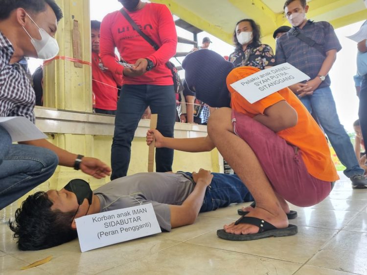 Foto pelaku memperagakan cara menghabisi nyawa korban.