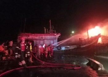 Petugas sedang berupaya memadamkan kebakaran kapal di Cilacap, Jawa Tengah, Selasa (3/5/2022). [Antara]
