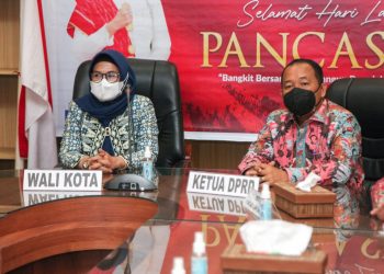 Plt. Wali Kota Pematangsiantar, dr. Susanti Dewayani Sp.A, bersama Ketua DPRD Pematangsiantar, Timbul Marganda SH saat mengikuti upacara peringatan Hari Kelahiran Pancasila secara virtual dari Command Center Balai Kota Pematangsiantar, Rabu (1/6/2022).