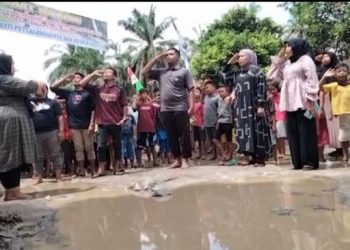 Warga di Asahan Kibarkan Bendera di Jalan Rusak. [Ist]