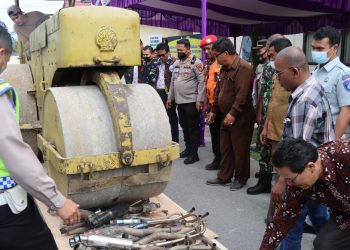 Ratusan knalpot brong dimusnahkan dengan cara memakai alat berat pemadat jalan, di halaman Mapolres Humbahas, Senin (27/6/2022).