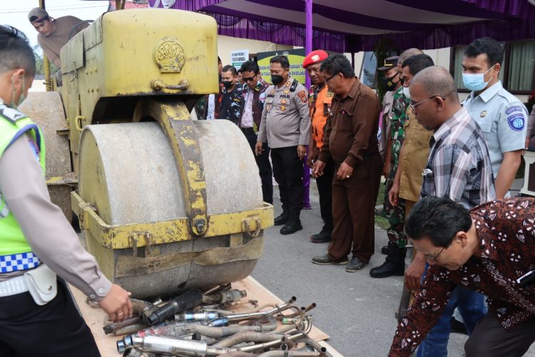 Ratusan knalpot brong dimusnahkan dengan cara memakai alat berat pemadat jalan, di halaman Mapolres Humbahas, Senin (27/6/2022).