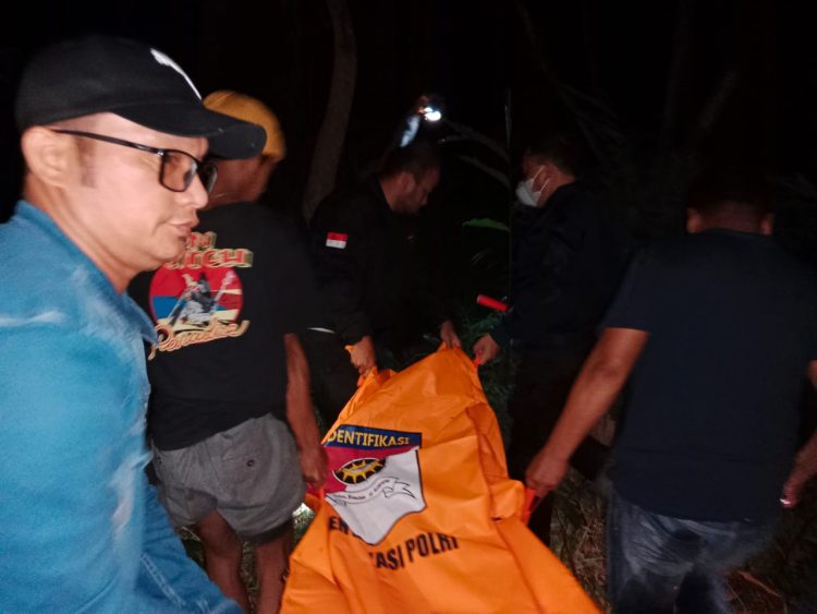 Petugas kepolisian saat mengevakuasi mayat korban dari lokasi kejadian.