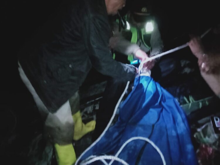 Petugas kepolisian saat mengevakuasi jenazah korban dari lokasi kejadian.