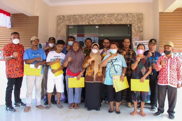 Plt. Wali Kota Pematang Siantar, dr Susanti Dewayani SpA, foto bersama warga korban bencana alam usai menyerahkan bantuan.
