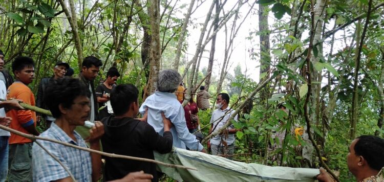 Petugas saat mengevakuasi jenazah korban (kemeja biru lengan panjang) dari lokasi kejadian.