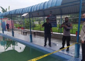 Petugas Polsek Helvetia menunjuk lokasi kolam renang tempat ditemukannya seorang bocah enam tahun tenggelam dan akhirnya meninggal, di Kolam Renang Sejahtera di Jalan Sejahtera, Kecamatan Medan Helvetia, Kota Medan, Minggu (31/7/2022). HO