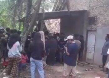 Warga berkerumun di lokasi penemuan jenazah satu keluarga yang dikubur di septic tank, Way Kanan, Lampung. (Yuswantoro/MNC Portal)