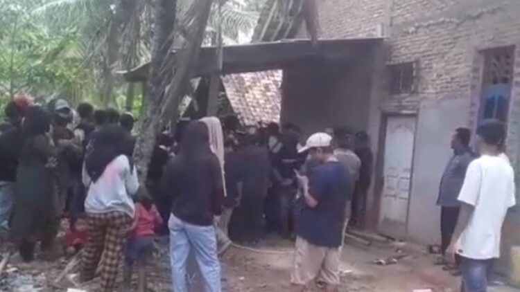 Warga berkerumun di lokasi penemuan jenazah satu keluarga yang dikubur di septic tank, Way Kanan, Lampung. (Yuswantoro/MNC Portal)