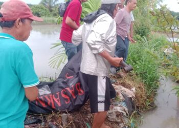 Warga bersama pihak keluarga dan petugas kepolisian mengevakuasi mayat korban.