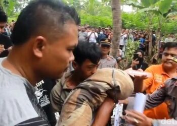 Foto: Tersangka saat melakukan reka adegan mencium salah satu korban (Tommy/detikSumut))