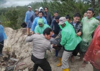 Personel Polisi saat mengevakuasi korban kecelakaan lalu lintas di jurang sedalam 100 meter di Aek Gulangan Siguloppong, Desa Meranti Barat, Kecamatan Silaen, Kabupaten Toba. Satu orang tewas ditempat, sementara 15 lainnya luka-luka. TRIBUN MEDAN/HO