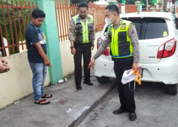 Petugas kepolisian saat melakukan olah TKP.