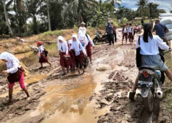 Siswa melintas di jalan lumpur (foto: MPI/Fadli)