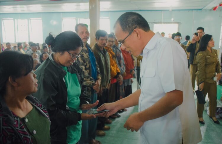 Bupati Humbang Hasundutan (Humbahas), Dosmar Banjarnahor SE, saat menyerahkan Bantuan Langsung Tunai kepada para warga penerima bantuan.