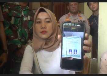 Dona memperlihatkan foto buku nikah saat menyampaikan klarifikasi di Polsek Pengandonan Kabupaten OKU, Kamis (29/12/2022). (Foto: Widori)