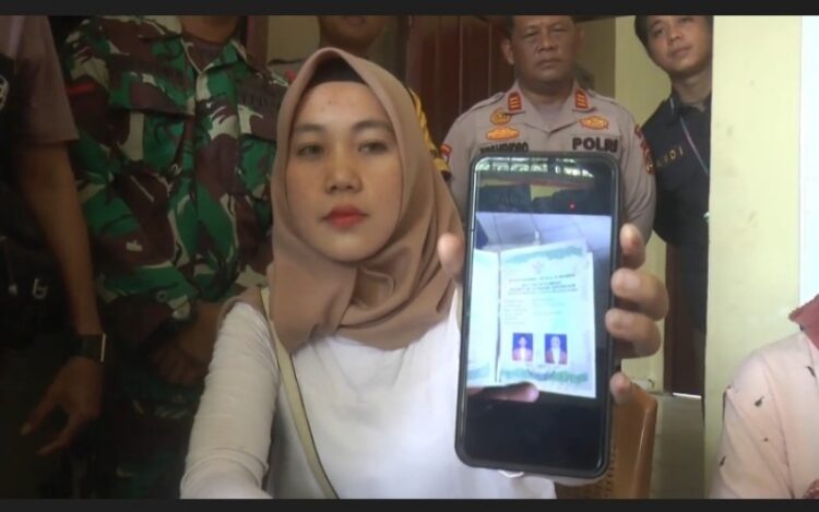 Dona memperlihatkan foto buku nikah saat menyampaikan klarifikasi di Polsek Pengandonan Kabupaten OKU, Kamis (29/12/2022). (Foto: Widori)