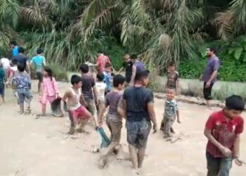 Puluhan anak-anak mengikuti lomba tangkap ikan di kubangan air yang terletak ditengah jalan Desa Padang Pulau, Kecamatan Bandar Pulau, Kabupaten Asahan, Jumat (2/12/2022), memprotes pemerintah terkait akses jalan yang tak pernah dibangun.   Tribun Medan/Alif Al Qadri Harahap