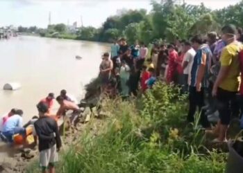 Suasana penemuan mayat pria tak dikenal mengapung di Sungai Silau, Kota Tanjungbalai, Sumatera Utara. (Foto : iNews/Ulil Amri)