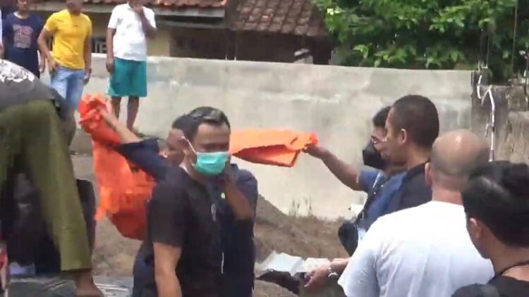Polisi mengevakuasi jenazah dari lubang di rumah tersangka Wowon dan Solihin. Jenazah itu dibawa ke Puslabfor Polri. (FOTO: iNews/M ANDI ICHSYAN)