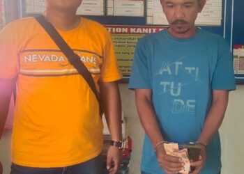 Foto pelaku judi togel memegang barang bukti.