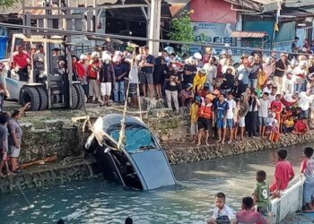 Mobil Honda Jazz terjun ke laut di Kota Baubau, Sultra, Sabtu (14/1/2023). Nampak proses evakuasi dilakukan. (Foto: Antara/Yusran)