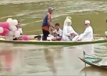 Sebuah video pasangan pengantin naik perahu di tengah banjir viral di media sosial. Pasangan pengantin ini memilih naik perahu karena jalan desa menuju lokasi resepsi pernikahan masih tergenang banjir. Foto SINDOnews