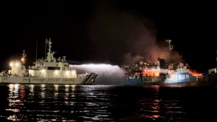 Kapal penjaga pantai Filipina berusaha memadamkan api di kapal fery MV Lady Joy yang terbakar di Basilan, Filipina, 30 Maret 2023. (Foto: Penjaga Pantai Filipina)