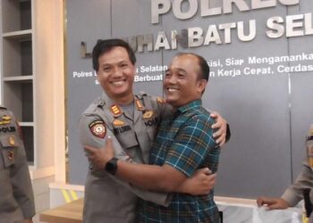 Kapolsek Torgamba AKP Luhut B Sihombing dan Aipda Rivo Sitorus saling berpelukan dan minta maaf usai viral cekcok bersama istrinya masing-masing. (Foto: iNews/Randi Kurniawan)