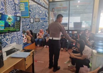 Kanit Regident Satlantas Polres Siantar, IPDA Muhammad Faizal S.Tr.K, saat bagikan minuman gratis kepada para pemohon SIM.