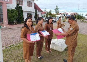 Tiga orang pegawai Dinas Kependudukan dan Catatan Sipil Kabupaten Humbahas, terima penghargaan dari Kadis Dukcapil, Jara Trisepto Lumbantoruan, S.Pd, MM, Senin (27/3/2023), saat apel gabungan ASN, di Komplek Tano Tubu Doloksanggul.