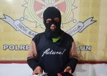 Foto terduga pelaku memegang barang bukti.