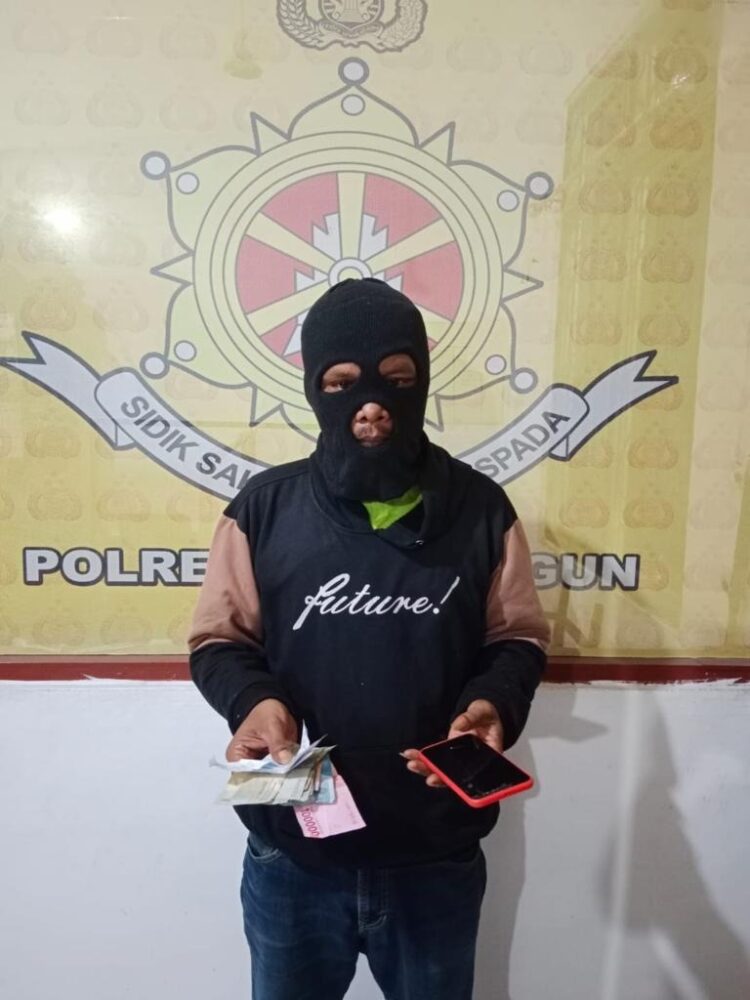 Foto terduga pelaku memegang barang bukti.