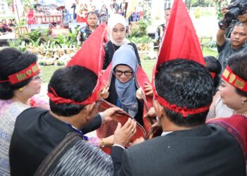 dr Susanti saat terima ulos dari PPSD Siahaan, di Jalan Gereja, tepatnya di Lapangan SMP YP HKBP, Minggu (12/03/2023).