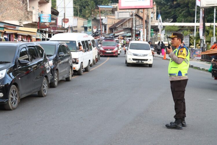 Kapolres Simalungun, AKBP Ronald F.C Sipayung, S.H., S.I.K, M.H, ikut turun tangan mengatur arus lalu lintas di kawasan Parapat.