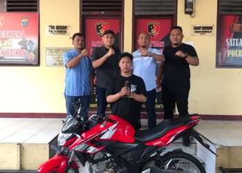 Foto pelaku curanmor dengan taangan diborgol dan barang bukti sepeda motor.
