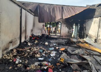 Personel Polsek Raya tampak turun tangan, membantu warga korban kebakaran.