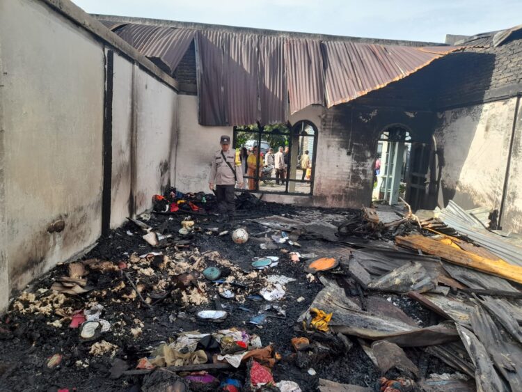 Personel Polsek Raya tampak turun tangan, membantu warga korban kebakaran.