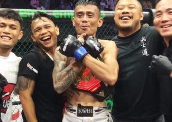 Petarung asal Kota Tebing Tinggi, Rustam Hutajulu (tengah), pose bersama sabuknya yang ia dapatkan di kelas strawweight usai menekuk petarung asal Lombok, Lalu Sofian, Sabtu (13/5/2023).