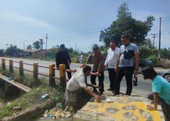 Warga Desa Sei Bulu, Kecamatan Teluk Mengkudu mengamankan pengendara sepeda motor yang mengalami kecelakaan di jalan lintas Sumatera tepatnya jembatan Sei Bulu Tiga, Kecamatan Teluk Mengkudu, Kabupaten Serdang Bedagai, Senin (1/5/2023). Tribun Medan/Anugrah Nasution