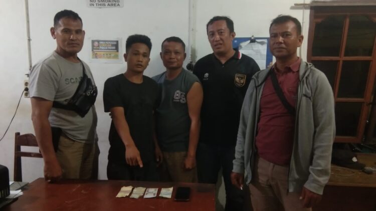 Foto tersangka lagi menunjuk barang bukti.