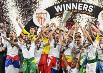 Para pemain Sevilla merayakan gelar juara Liga Europa 2022-2023 di atas podium dengan mengangkat trofi setelah mengalahkan AS Roma lewat drama adu penalti di final Liga Europa 2022-2023 di Puskas Arena di Budapest pada 31 Mei 2023. Mereka juara Liga Europa 2022-2023 usai menang adu penalti 4-1 setelah bermain imbang 1-1 dengan AS Roma sepanjang 120 menit. Attila KISBENEDEK/AFP