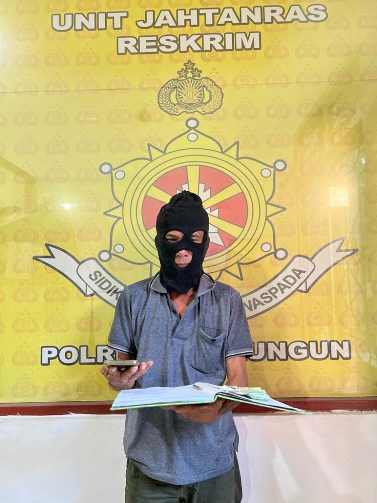 Foto pelaku judi Togel saat memegang barang bukti.