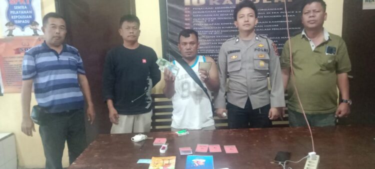 Foto tersangka memperlihatkan barang bukti.