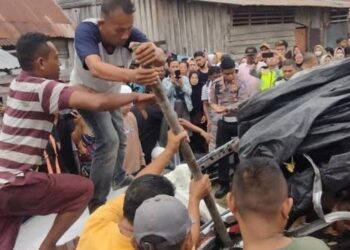 Sejumlah warga berupaya mengevakuasi dua penumpang minibus yang tertabrak KA Sri Bilah di Asahan, Selasa (18/7/2023). (Foto: MPI/Wahyudi Aulia S)